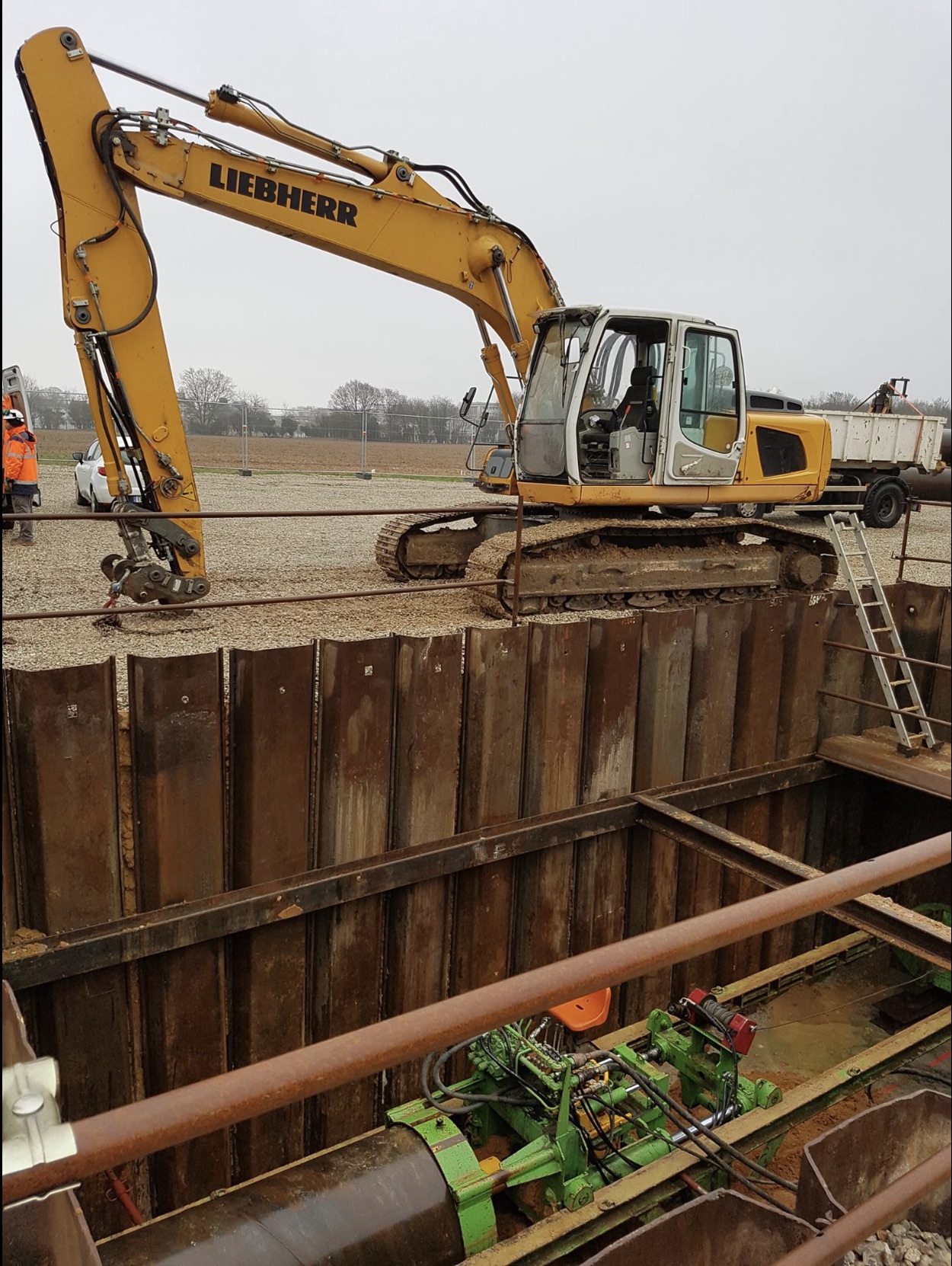 Pelle sur fouille blindée par palplanches, chantier de travaux spéciaux